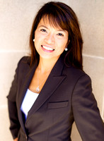 Woman with long brown hair in front of stone wall